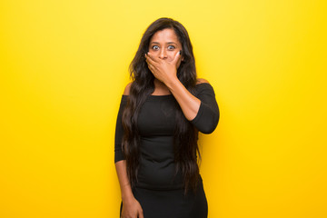 Young afro american woman on vibrant yellow background covering mouth with hands for saying something inappropriate