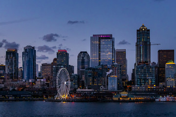 Seattle skyline and waterfront by night from Ellott Bay, Puget Sound, Washington state, USA.