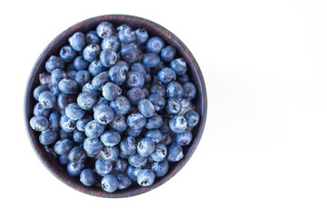 Fresh Blueberry in wooden cup on white table background