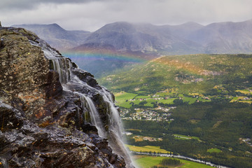 mountain landscape with hydenfossen waterfall, the end of earth, rainbow