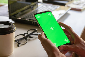 Newsletter concept Hand of businessman or designer checking message box on digital mobile phone on mock up green screen,Vintage tone filter.