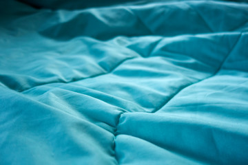 Green blanket on bed close up for background