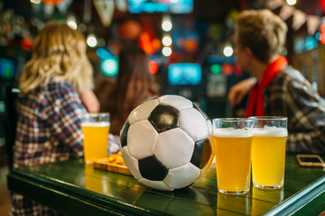 Ball and beer on the table in sports bar