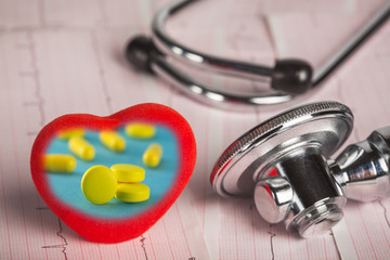 Pills and medical stethoscope with cardiogram.Conceptual medicine.