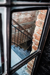 black iron staircase brick wall, creative space. loft office. coworking. view through glass door