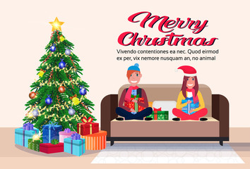 couple sitting on couch modern living room merry christmas happy new year decorated gift boxes pine tree flat horizontal copy space