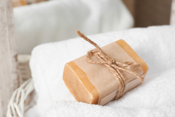 Soap bar and clean towel in laundry basket, closeup. Space for text