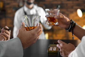 Friends drinking whiskey together in bar, closeup