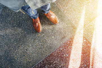 Top view of brown leather shoes. Glare of sunlight on the concrete floor. life Empty background