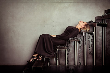 Beautiful model posing in sexy dress at black studio