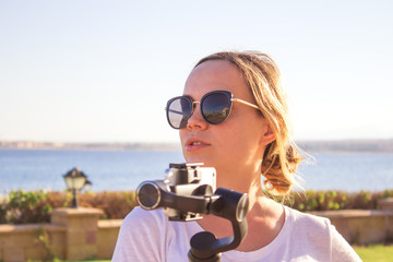 Young attractive man films a travel video using the steadycam gimbal and a Phone.