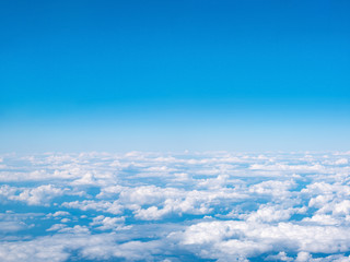 Luchtfoto van blauwe lucht en witte wolken. Bovenaanzicht vanuit vliegtuigraam