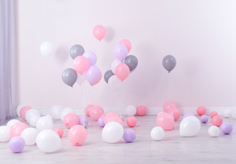 Room decorated with colorful balloons near wall