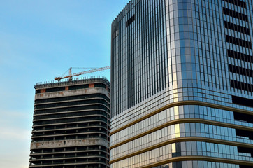 Construction of a high-rise office building skyscraper.  Glass windows in a multi-storey apartment and office building. Windows of modern city business building skyscraper, background, texture