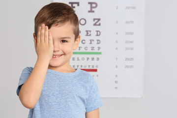 Cute little boy visiting children's doctor, space for text. Eye examination - obrazy, fototapety, plakaty