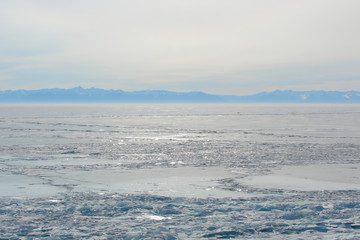winter landscape with a frozen mountain lake; breaking ice, hummock