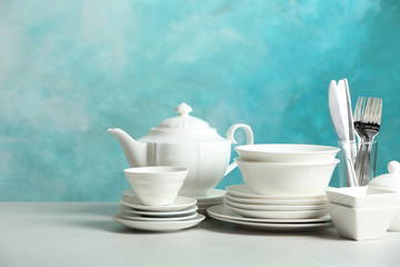 Set of clean dishes on table against blurred background. Space for text