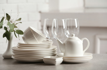 Fototapeta na wymiar Set of clean dishes on table against blurred background