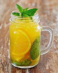Orange lemonade in a cup on a wooden background