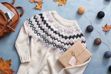 Flat lay composition with warm sweater on color background
