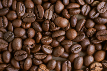 Roasted coffee beans on rustic wooden background. Food ingredients, top view, space for text