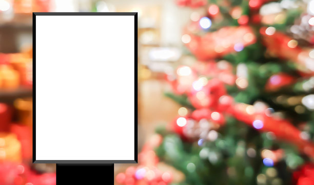 mock up blank white poster standing on blur shopping store with christmas decorate background for show or promote promotion	
