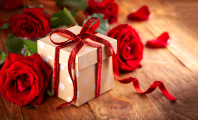 Gift box with red ribbon bow and red roses