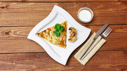 Pancakes with meat and mushrooms on a wooden background, top view