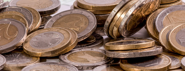 Niekolko euro mincí na rôznych pozíciách  na bielom pozadí detailný záber