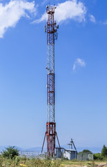 Communications tower on top of a hill complete with various antennas and microwave and satellite dishes