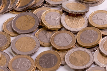 Niekolko euro mincí na rôznych pozíciách  na bielom pozadí detailný záber