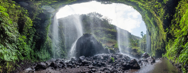Majestic Madakaripura waterfall flowing on rocky cliff