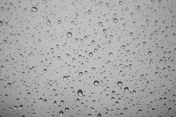 raindrops on window glass on background of cloudy sky