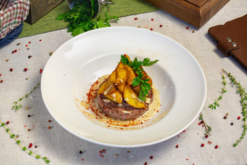Meat steak with potatoes on a plate in a restaurant