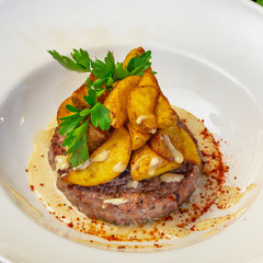 Meat steak with potatoes on a plate in a restaurant