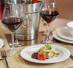 Dinner at the restaurant, dish and wine on the table