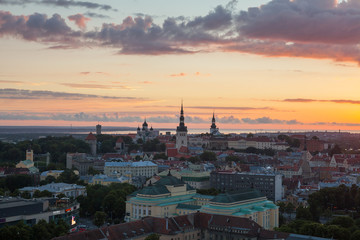 Fototapeta na wymiar TALLINN, ESTONIA - AUGUST 28, 2017: Skyline with old town church towers and modern buildings in background. Sunset time and epic sky.