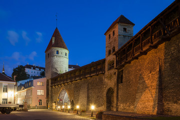 Fototapeta na wymiar Scenic view of the evening street and the wall with towers in the Old Town in Tallinn, Estonia