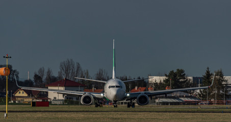 Fototapeta premium Front view of landing of white airplane in capital Prague