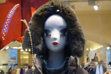 Mannequin's head in a  grey fur hood enormous eyelashes and red lips