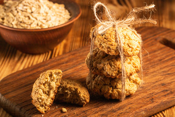 Homemade oatmeal cookies on wooden board on old table background