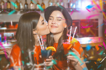 Confetti party. Two young lesbian girls kissing at a club party.