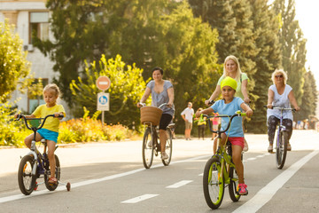 Theme family active sports outdoor recreation. A group of people is a big family of 6 people standing posing on mountain bikes in a city park on a road on a sunny day in autumn.