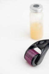 Dermaroller needle with serum in glass bottle. Anti wrinkle skin care.