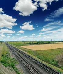 Fototapeta na wymiar railroad to horizon in blue sky with clouds