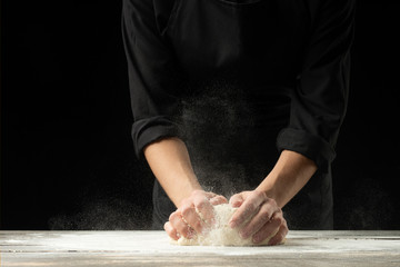 Cook baker prepares bread, focaccia, pizza, buns, sweets. Horizontal photo. Bakery concept, cooking...
