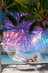 woman in  hammock on background of the sea and palm and Festive fireworks..