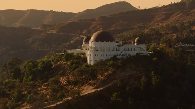 Cinematic Aerial of Griffith Observatory with  The Hollywood  Sign as background / Los Angeles, California 