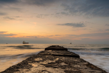 Sunrise over the sea - water, sand and ship.