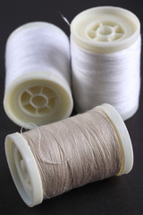 Bobbins with threads on the background of an old wooden table